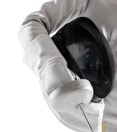 Close up of teen girl in fencing costume with sword in hand isolated on white studio background. Young female caucasian model in motion, action. Confident. Copyspace. Sport, youth, healthy lifestyle.